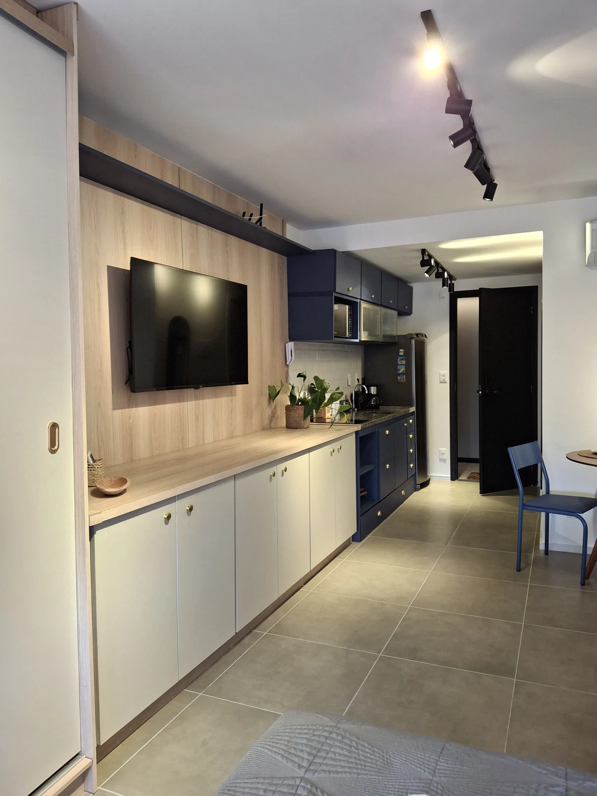 Painel de televisão em madeira integrado à cozinha planejada
